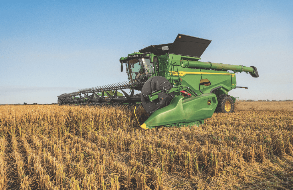 John Deere combine harvesting in a farm field 